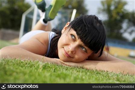 closeup of beautiful dreamy woman face that lies on grass