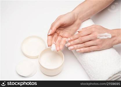 Closeup of beautiful female hand applying hand cream over grey backgroud.. Closeup of beautiful female hand applying hand cream over grey backgroud