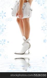 closeup of beautiful legs in white boots with purse