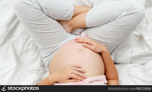 Closeup of beautiful mother hands stroking and touching gently big pregnant belly. Beautiful pregnancy and anticipation of baby.. Closeup of beautiful mother hands stroking and touching gently big pregnant belly. Beautiful pregnancy and anticipation of baby