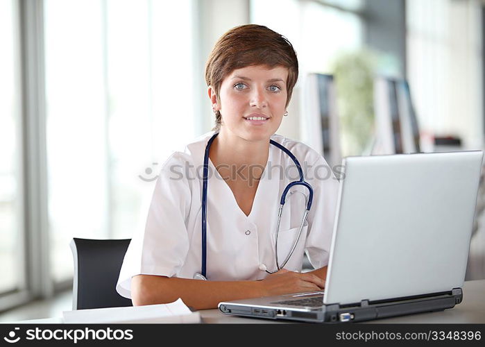 Closeup of beautiful nurse in front of laptop computer