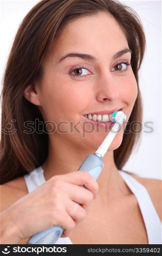 Closeup of beautiful woman brushing her teeth