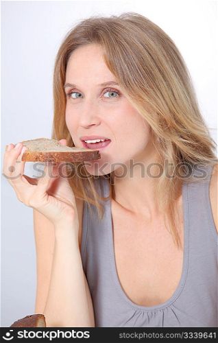 Closeup of beautiful woman eating slice of bread