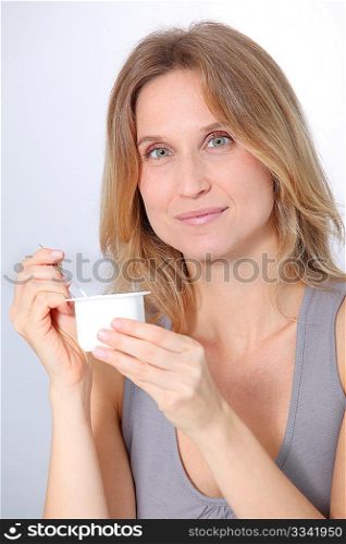 Closeup of beautiful woman eating yogurt