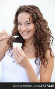 Closeup of beautiful woman eating yogurt