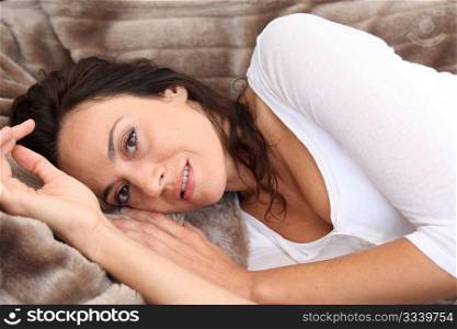 Closeup of beautiful woman laying in soft blanket
