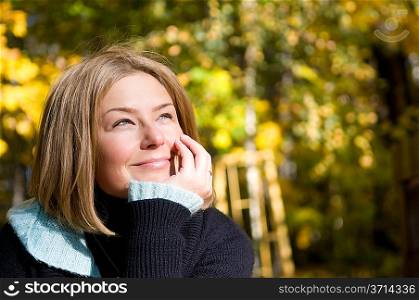Closeup of beautiful woman thinking over autumn background