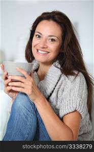 Closeup of beautiful woman with hot drink at home