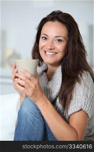 Closeup of beautiful woman with hot drink at home