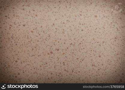 Closeup of beige brown spotted texture as background backdrop pattern, vignette