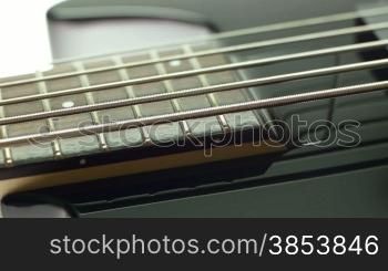 Closeup of black five cords electric bass fretboard and pickups. Dolly shot, sequence