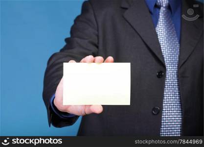 Closeup of blank business note card or signboard in man&#39;s hand blue background