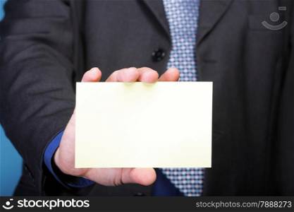 Closeup of blank business note card or signboard in man&#39;s hand blue background