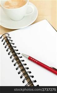 Closeup of Blank Notebook With Ballpoint and Espresso Coffee on Wooden Table