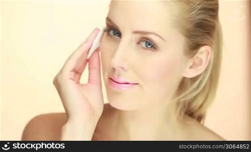 closeup of blonde woman cleaning her face