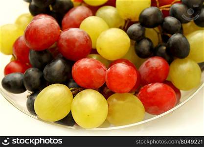 Closeup of bright tasty ripe grapes in a glass plate
