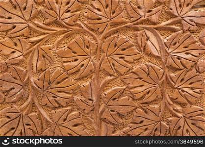 Closeup of brown woodcarving of branches and leaves in geometric design