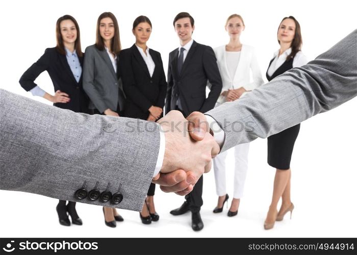 Closeup of business handshake. Closeup of business handshake, team of business people on background, isolated on white