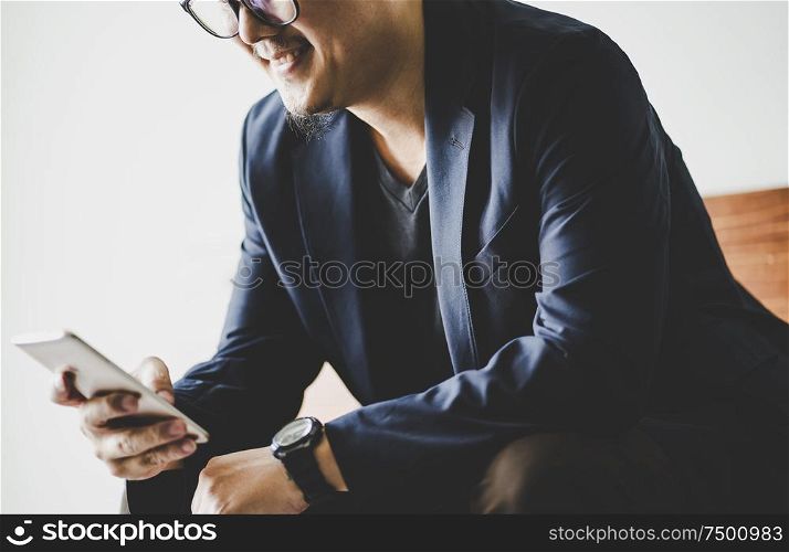 Closeup of businessman using smartphone .