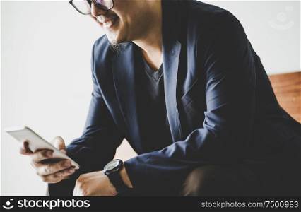 Closeup of businessman using smartphone .
