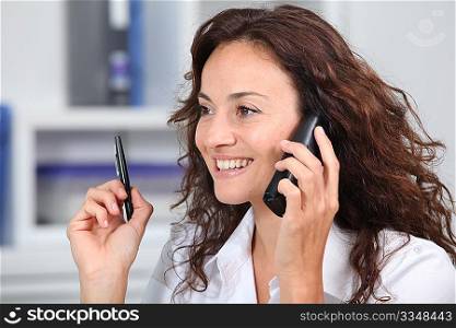 Closeup of businesswoman in the office talking on the phone
