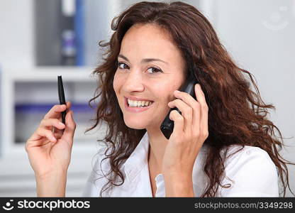 Closeup of businesswoman in the office talking on the phone