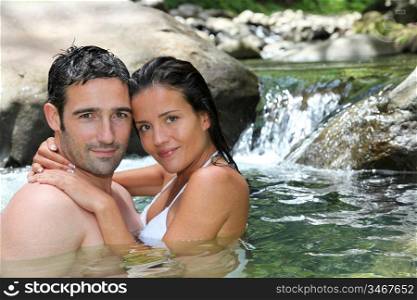 Closeup of cheerful couple bathing in river