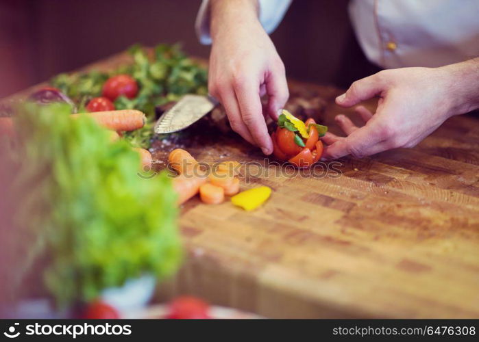 closeup of Chef hands in hotel or restaurant kitchen preparing beef steak with vegetable decoration. closeup of Chef hands preparing beef steak