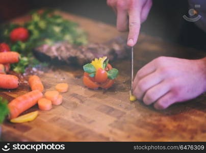 closeup of Chef hands in hotel or restaurant kitchen preparing beef steak with vegetable decoration. closeup of Chef hands preparing beef steak