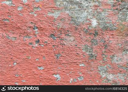 Closeup of chipped paint on old red wall