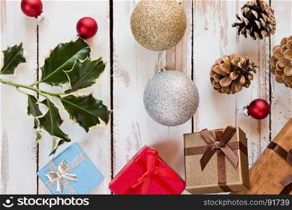 Closeup of Christmas presents and decorations over a rustic wooden table seen from above. Closeup of Christmas presents and decorations over a rustic wooden table