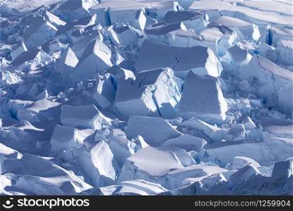 Closeup of chunks of ice on glacier tongue shimmering blue in Antarctic sunlight