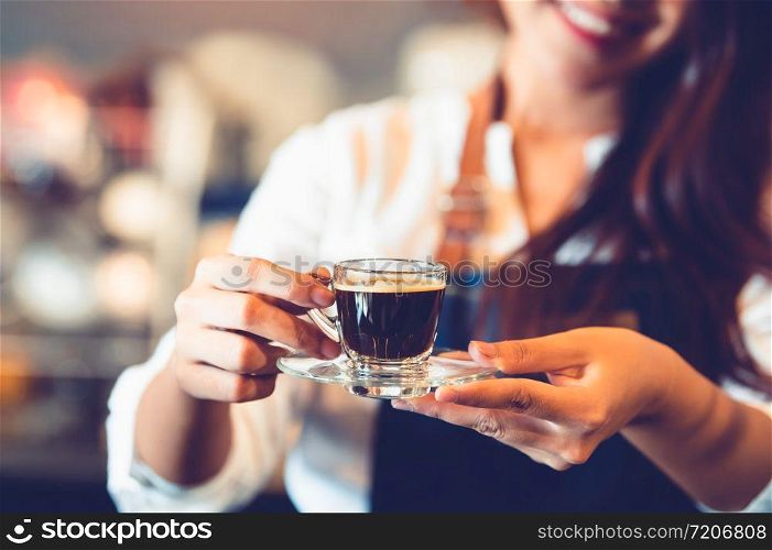 Closeup of coffee cup with beautiful Asian woman barista background for making coffee to serving to customer. Job and occupation. Food and drink beverage. Coffee shop and Cafe. Business and restaurant