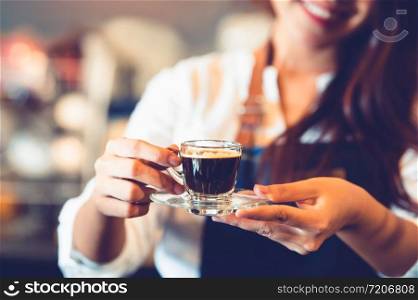 Closeup of coffee cup with beautiful Asian woman barista background for making coffee to serving to customer. Job and occupation. Food and drink beverage. Coffee shop and Cafe. Business and restaurant