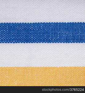 Closeup of colorful blue yellow white horizontal striped fabric textile as background texture or pattern. Macro.