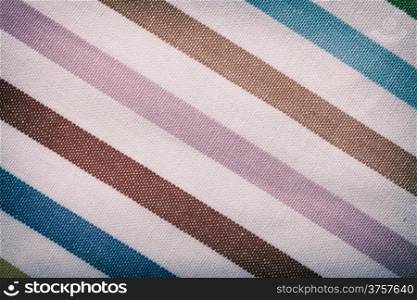 Closeup of colorful diagonal striped fabric textile as background texture or pattern. Macro.