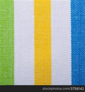 Closeup of colorful green yellow blue vertical striped fabric textile as background texture or pattern. Macro.