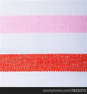 Closeup of colorful red pink white horizontal striped fabric textile as background texture or pattern. Macro.