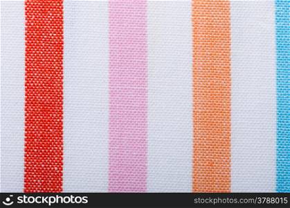 Closeup of colorful vertical striped fabric textile as background texture or pattern. Macro.