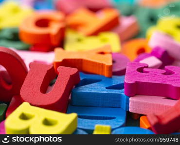 closeup of colorful wooden alphabet on green background.