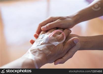 Closeup of couple holding hands in hospital