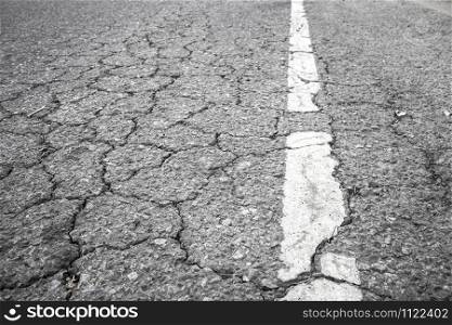 closeup of cracked asphalt road