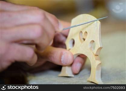 Closeup of craftsman making musical instrument bridge