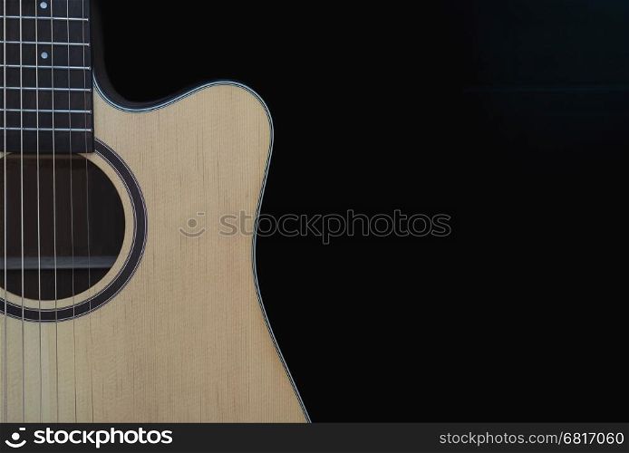 Closeup of cutaway acoustic guitar over black background