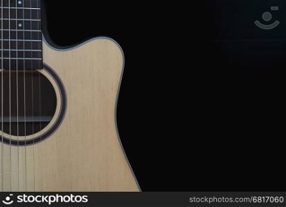 Closeup of cutaway acoustic guitar over black background