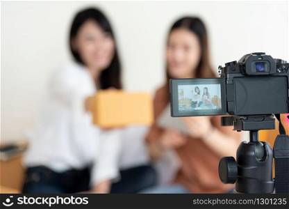Closeup of digital video camera recording two girls presenting new product advertisement. Vlog and influencer concept. People part time job and occupation. Young teenagers using modern technology