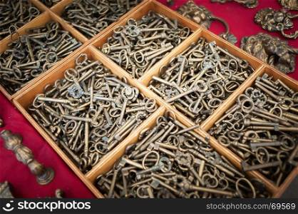 Closeup of display of old and brass reproduction keys in bulk for decoration or collection sold at flea market