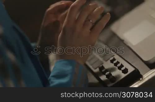Closeup of dj hands playing beats, pushing the button on live performance using professional beat maker equipment MPD. Disc jockey playing beats on pad controller.