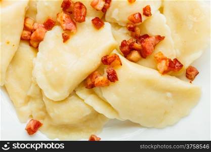 Closeup of dumplings sprinkled with pork scratchings as food background. Traditional polish (Poland) cuisine.
