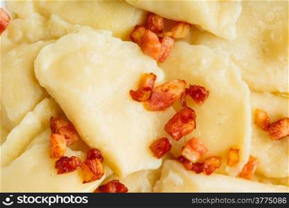 Closeup of dumplings sprinkled with pork scratchings as food background. Traditional polish (Poland) cuisine.